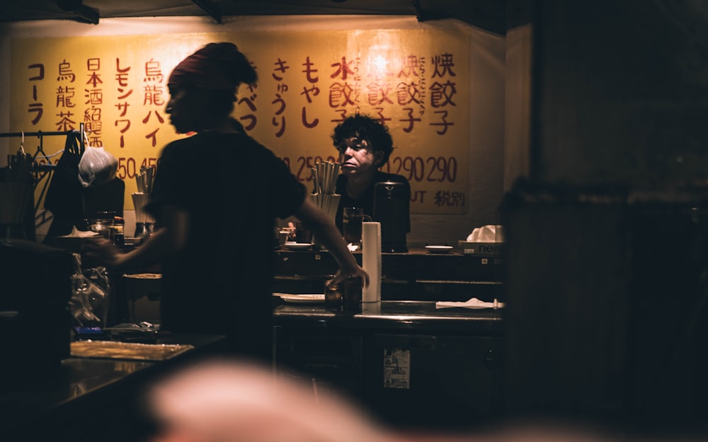 man standing front of man on desk