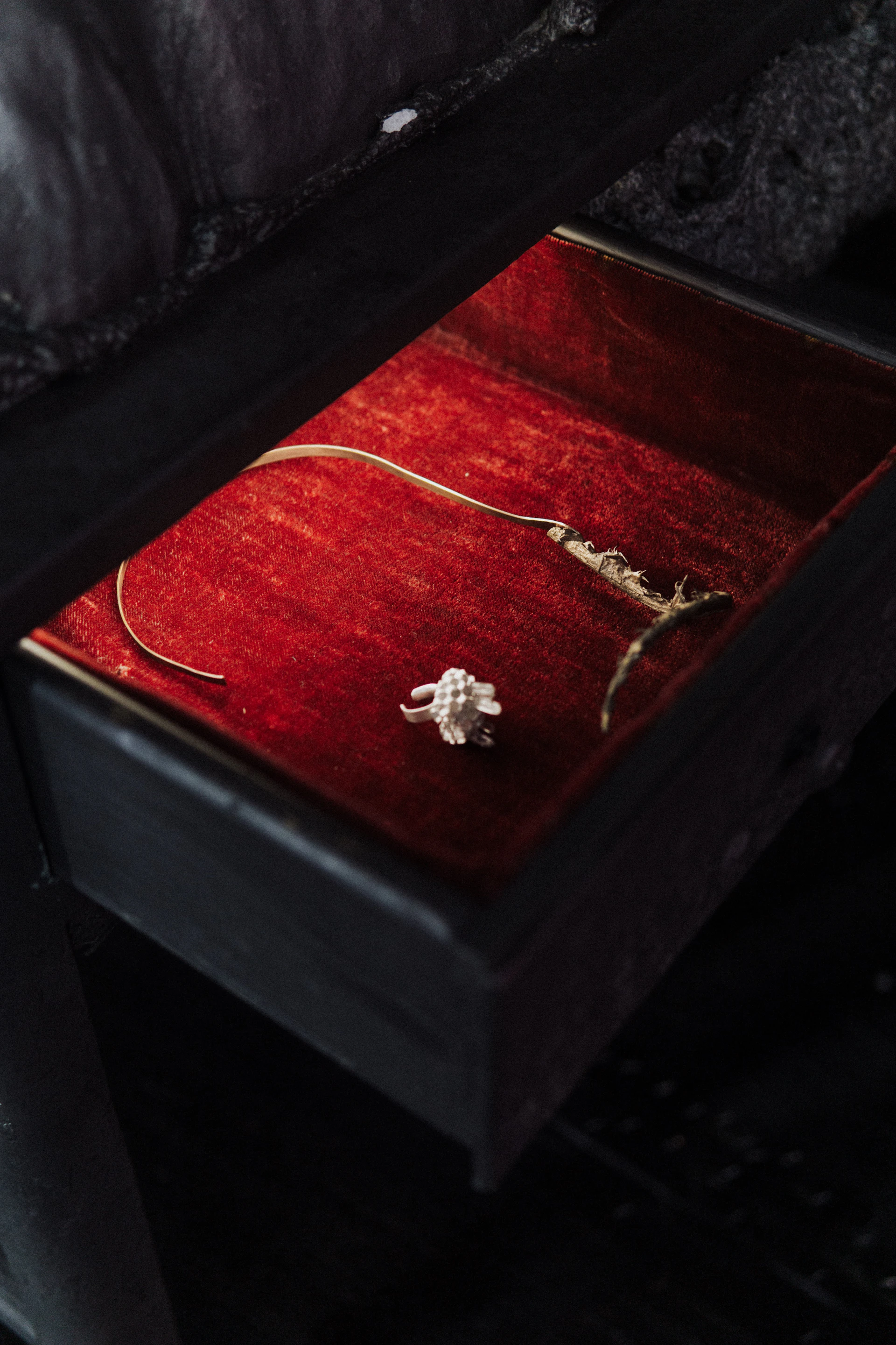 silver diamond studded ring on brown wooden box