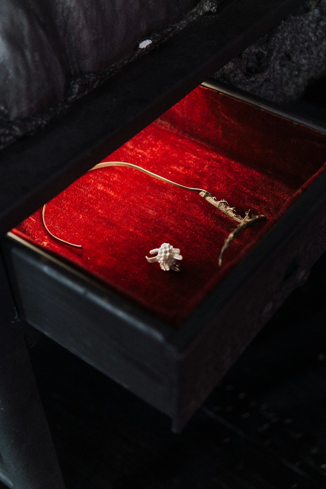 silver diamond studded ring on brown wooden box