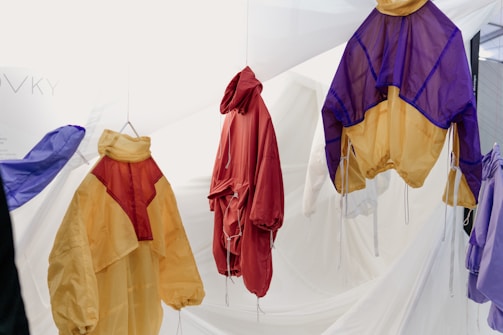 A vibrant display of colorful leggings and brassières hanging in a sunlit studio.
