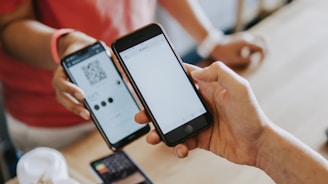 two person's hands holding turned-on phones