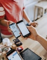 two person's hands holding turned-on phones