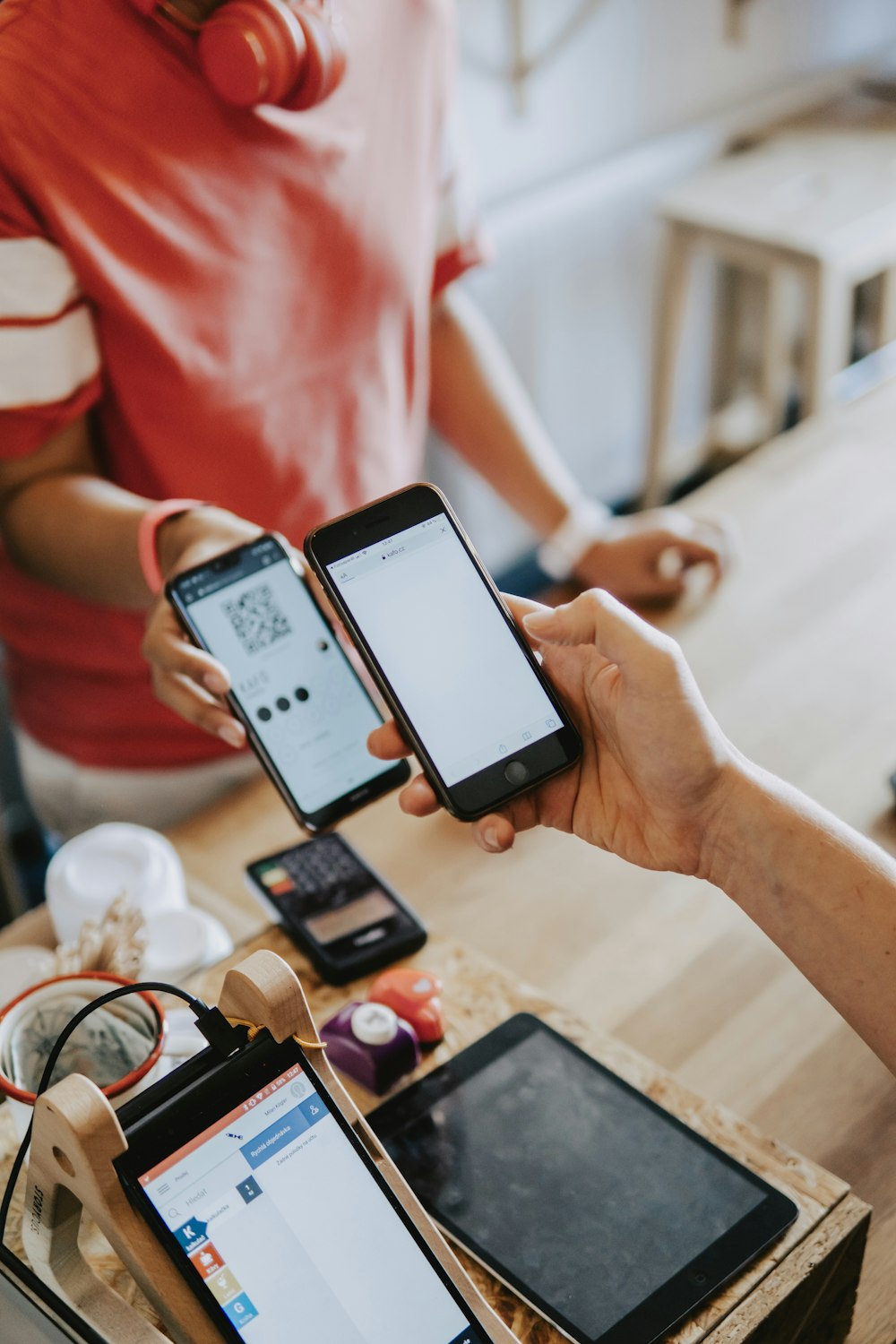 mãos de duas pessoas segurando telefones ligados