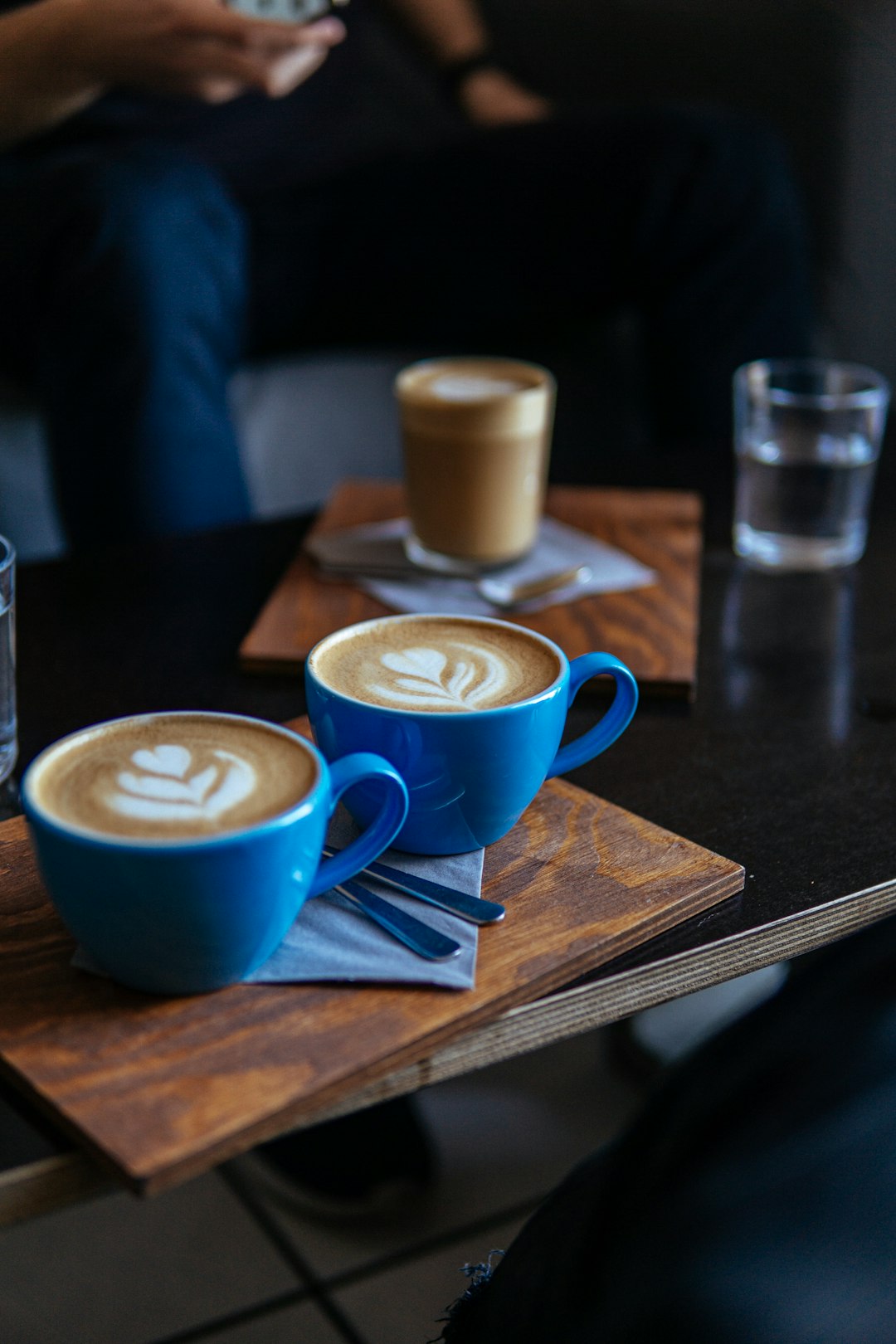 two blue ceramic mugs on brown table