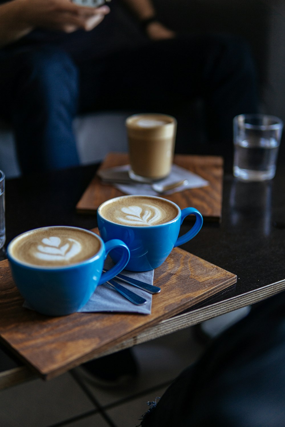 two blue ceramic mugs on brown table