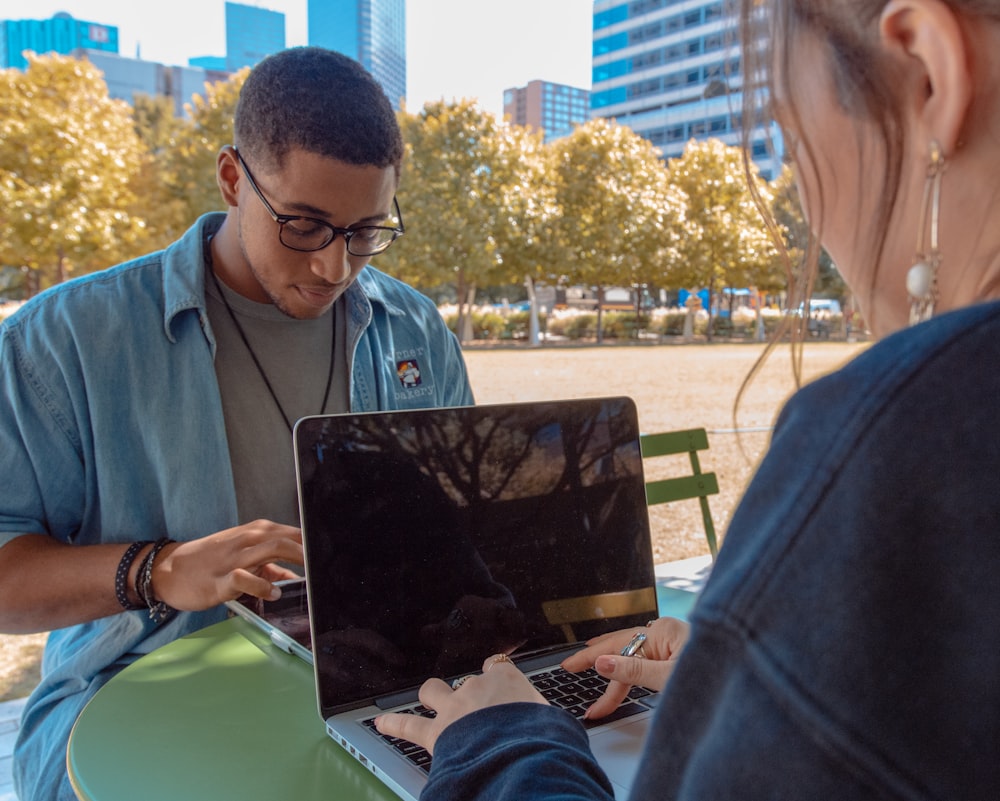 hombre y mujer sentados mientras usan MacBook Pro