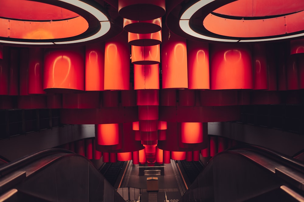 an escalator in a building with red lights