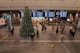 group of people inside building with Christmas tree