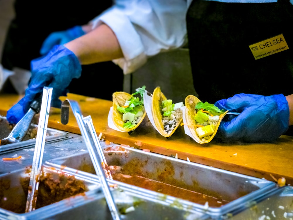 person about to put sauce on tacos