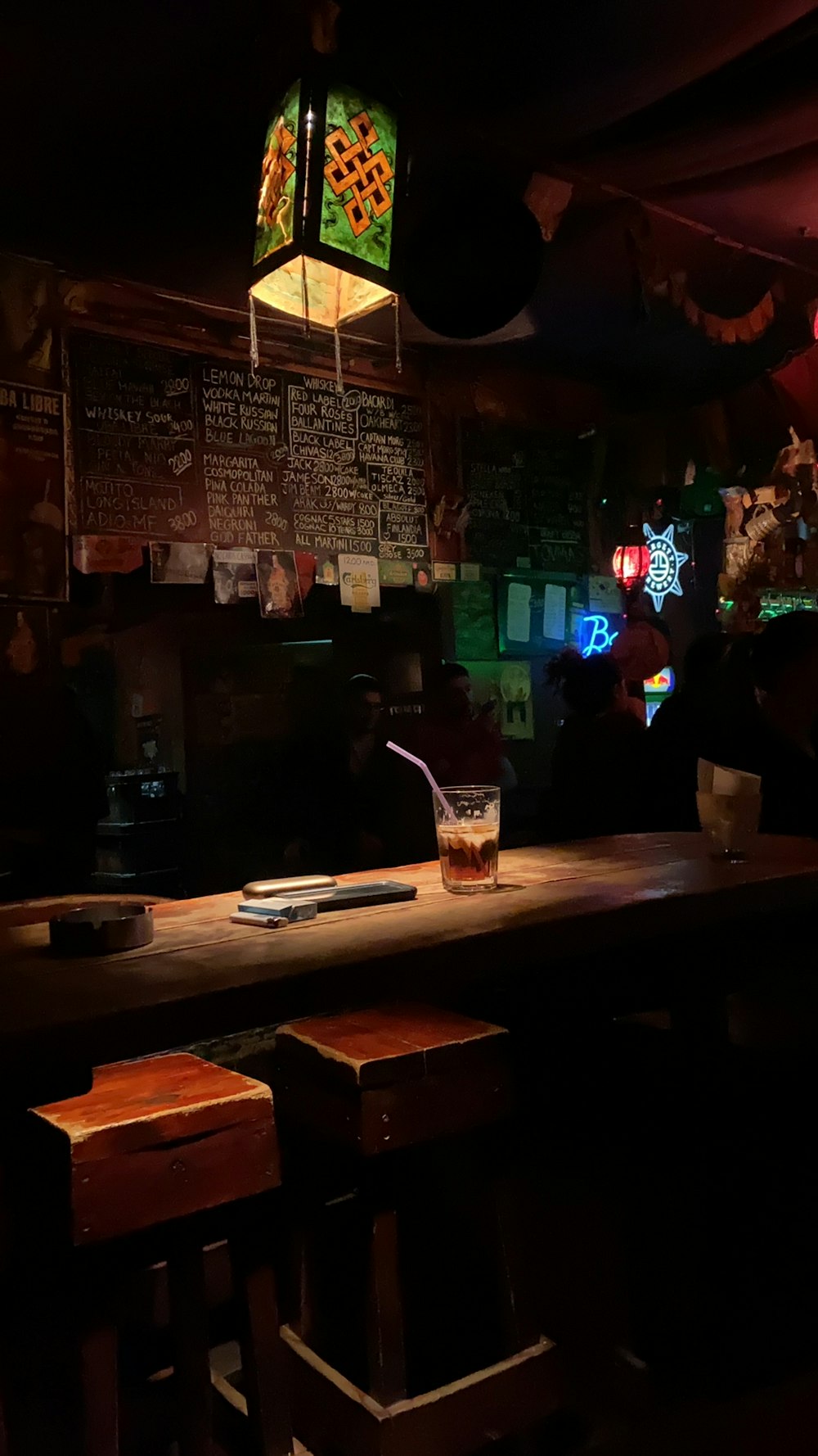 low-light photo of glass with straw on brown table