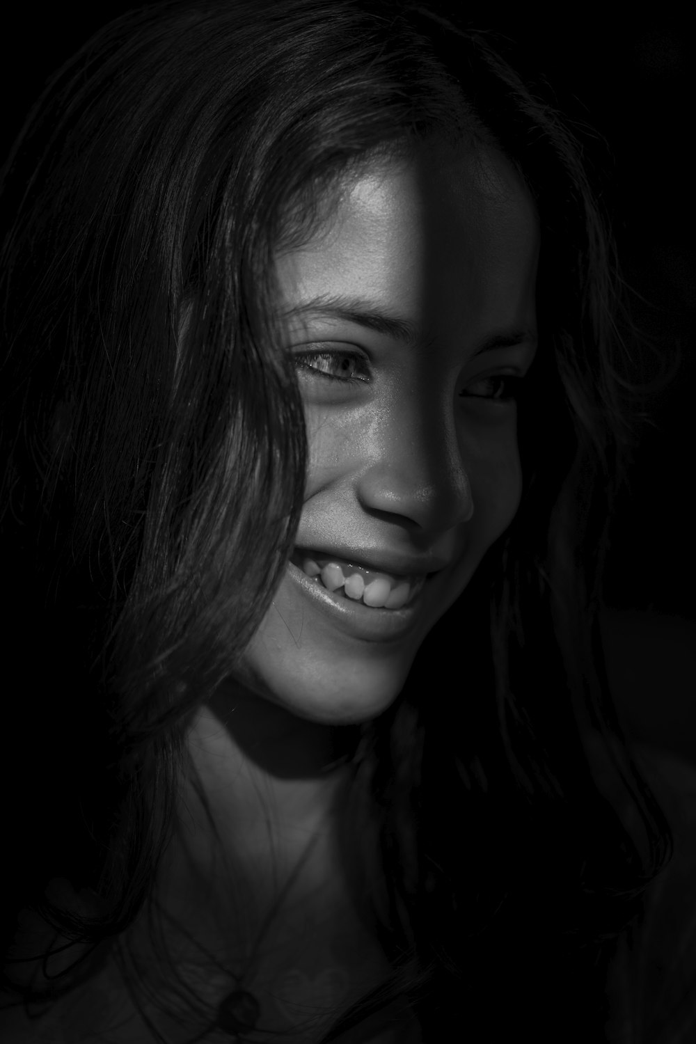 a black and white photo of a woman smiling