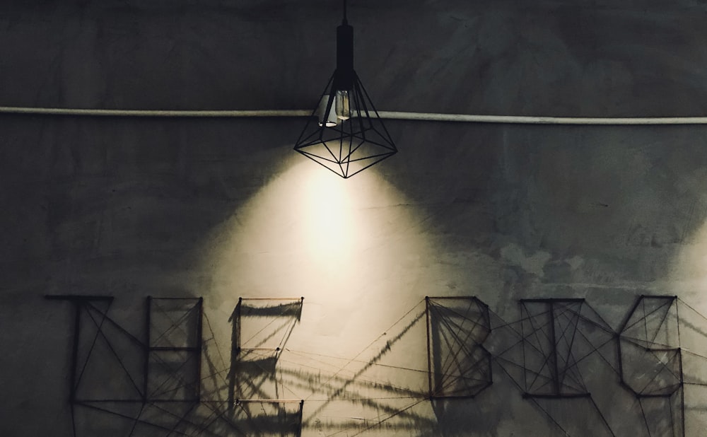 black pendant lamp and gray concrete wall