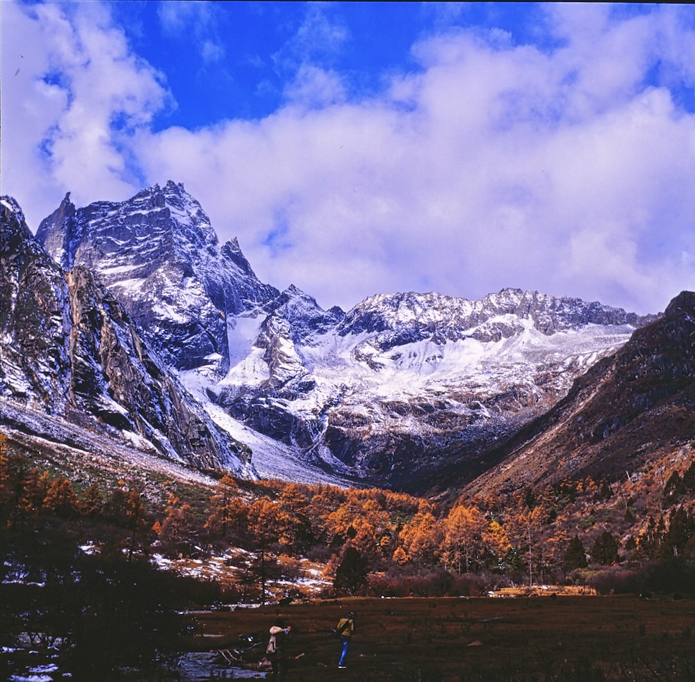 couple walks on landscape with snowy mountain background