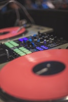 A close-up of turntables with vibrant lights in the background.