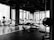A modern gym with an array of exercise equipment such as treadmills, elliptical machines, and weight benches. Large windows along the wall allow natural light to illuminate the space. The floor is equipped with rubber mats for safety and comfort.