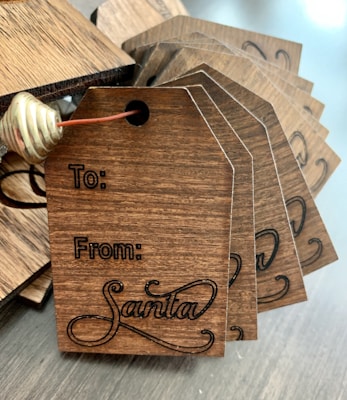 An assortment of engraved tags laid out on a wooden table.