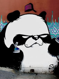 A stylized graffiti art piece depicting a panda with an intense expression, holding spray paint cans. The background features geometric patterns and drips of blue paint.