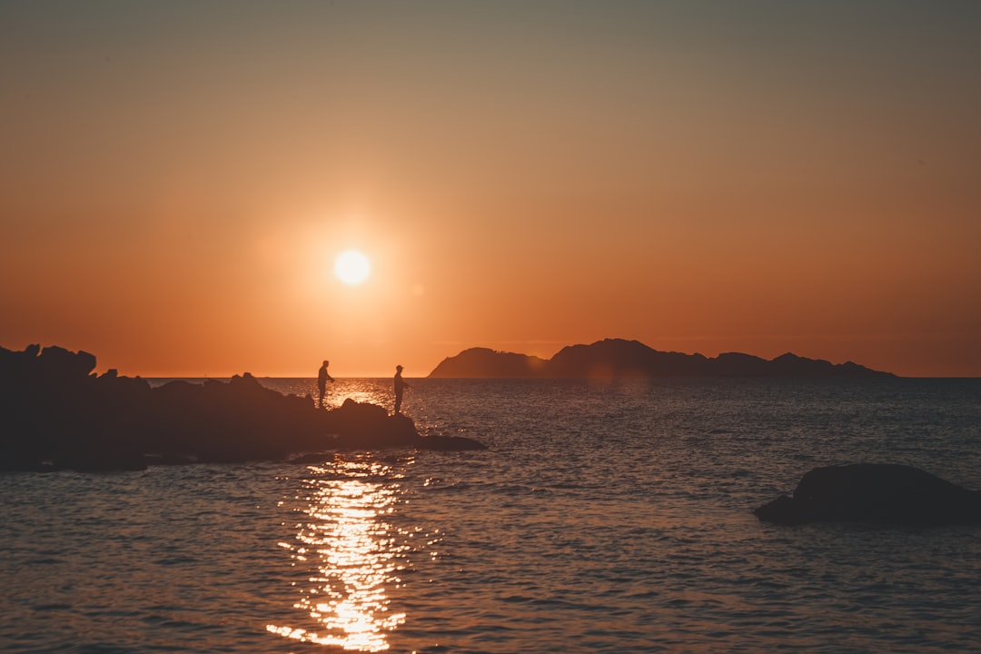 silhouette of men near body of water