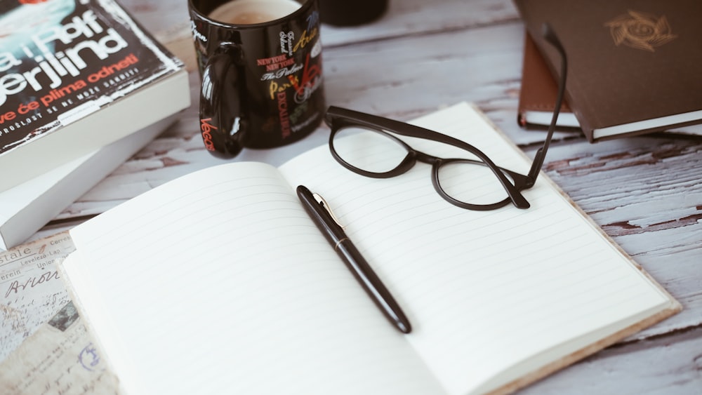 black-framed eyeglasses on book