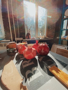 A serene, sunlit room with colorful art and healing crystals scattered on a wooden table.