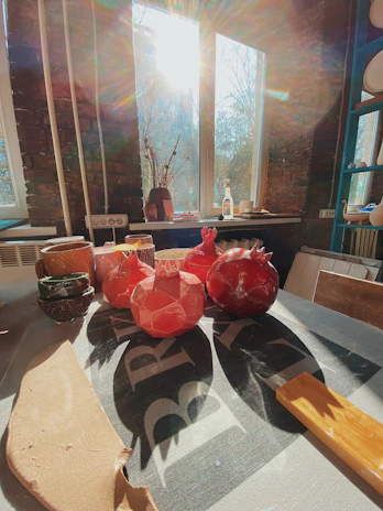 Sunlight filtering through a window onto a collection of handmade ceramic vessels inspired by Andean shapes.
