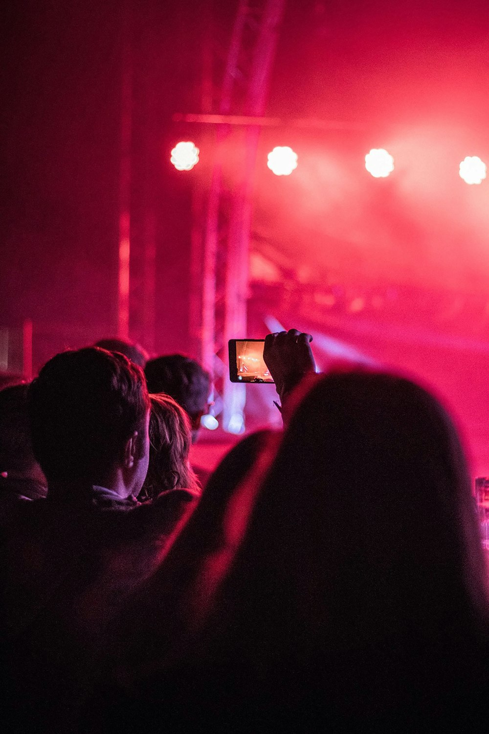 man holding smartphone near stage