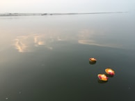 Floating diyas (small lamps) drifting gently on the sacred waters of the Ganga at dusk.