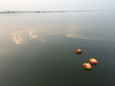 A beautifully decorated boat with candles and flowers floating on the Ganges at sunset.