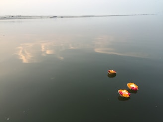 Floating diyas (small lamps) drifting gently on the sacred waters of the Ganga at dusk.