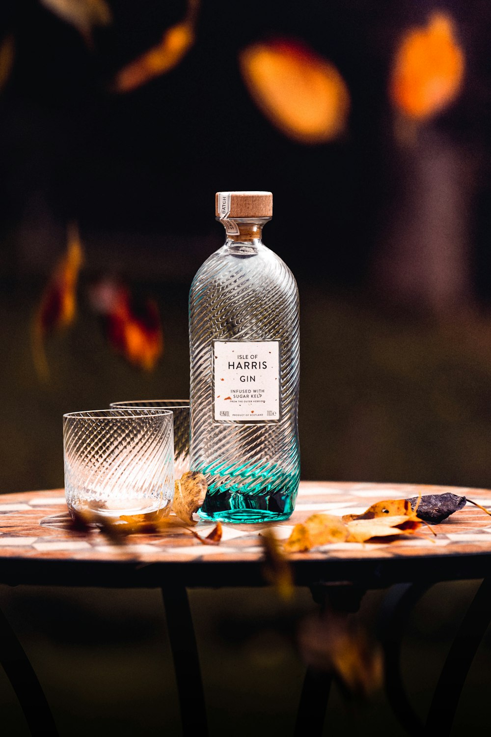 Harris Gin bottle and drinking glass on round table