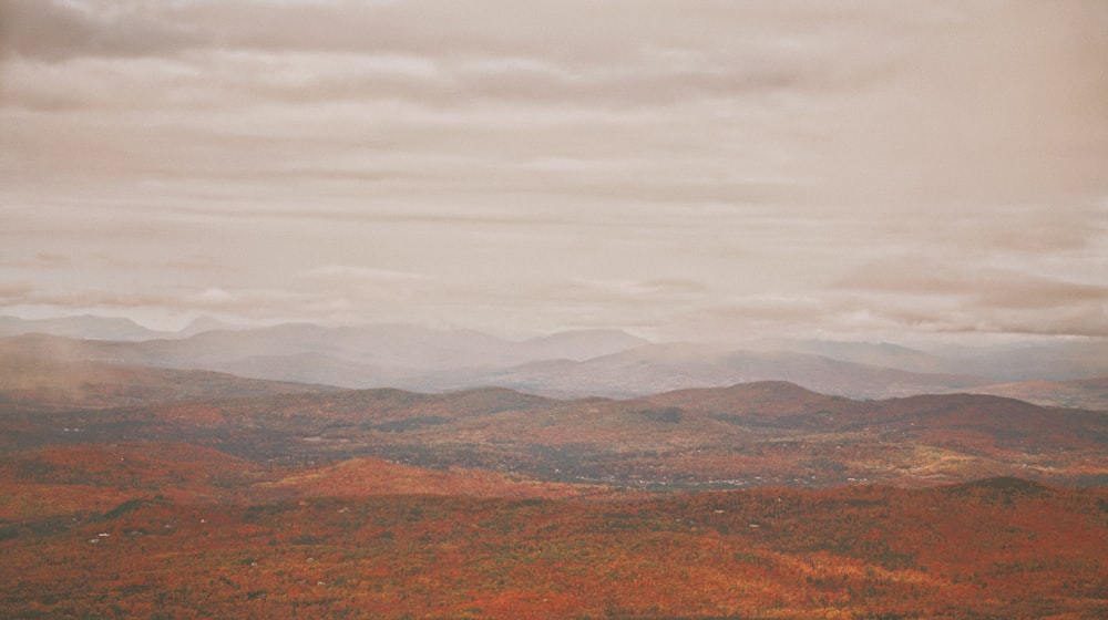 aerial photo of mountains under cloudy sky