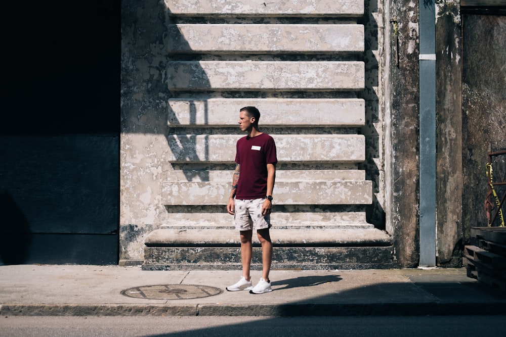 a man standing on a sidewalk in front of a building