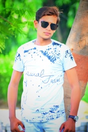 A model wearing a stylish navy t-shirt in a park.