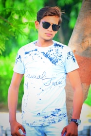 Model lounging outdoors wearing a blue Wearix Tee paired with relaxed jeans.