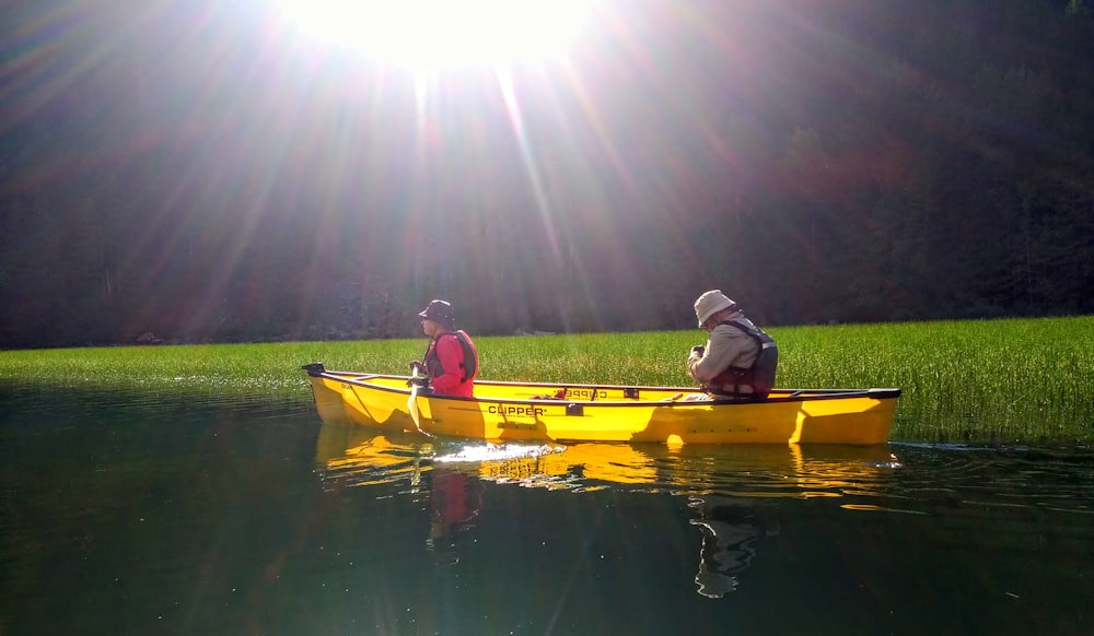 two people in a yellow canoe on a lake