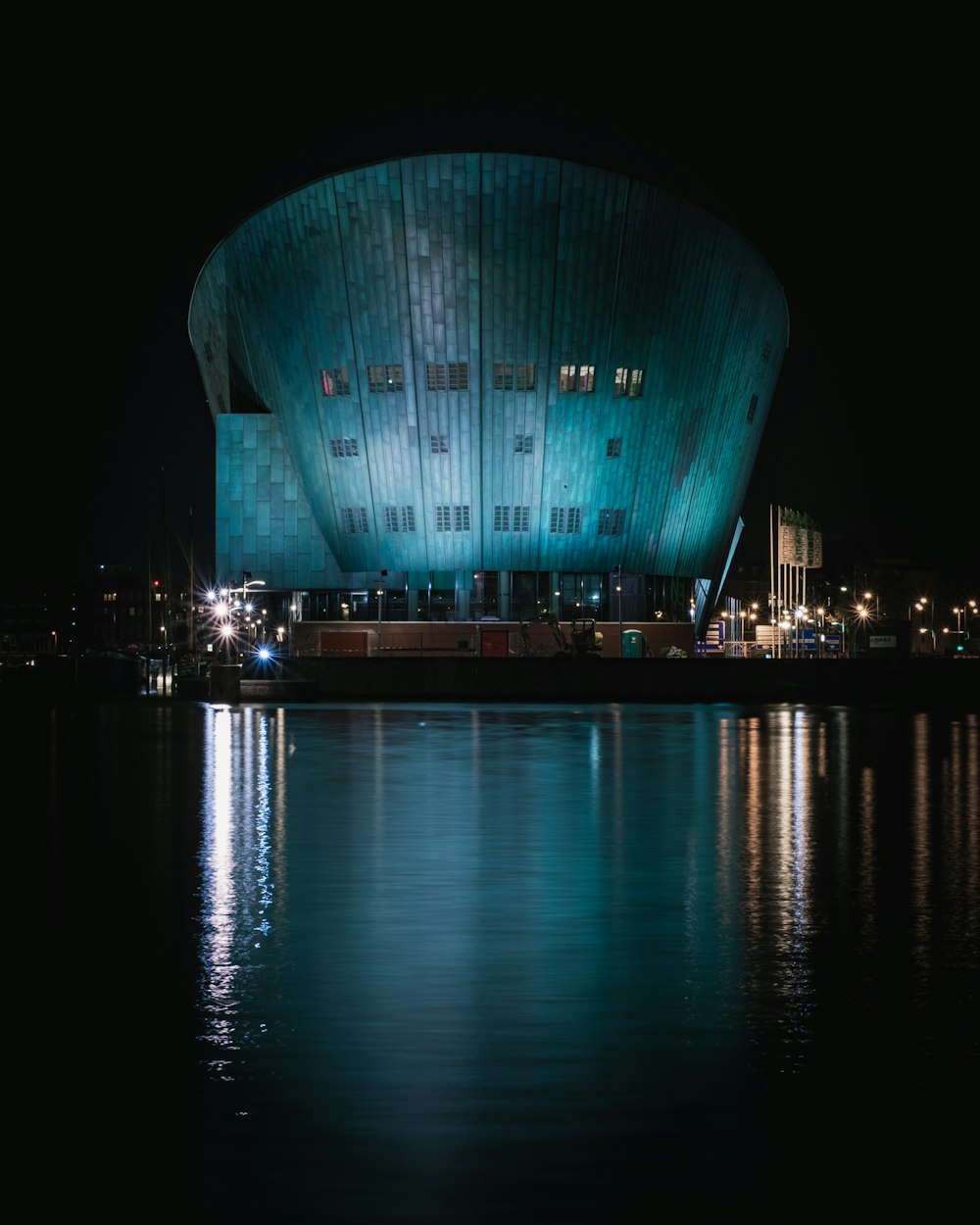 body of water near building during nighttime