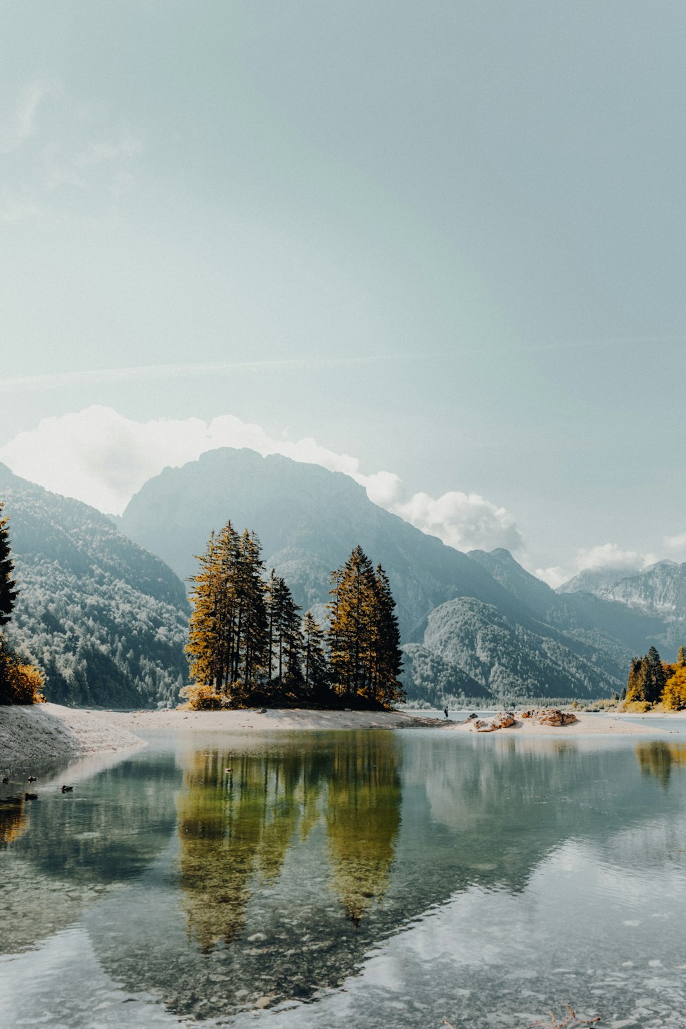 body of water near mountain painting