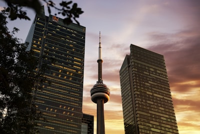 The iconic CN Tower lit up against a twilight Toronto skyline.