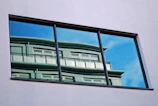 Close-up of a sleek modern window with triple glazing reflecting a bright blue sky.