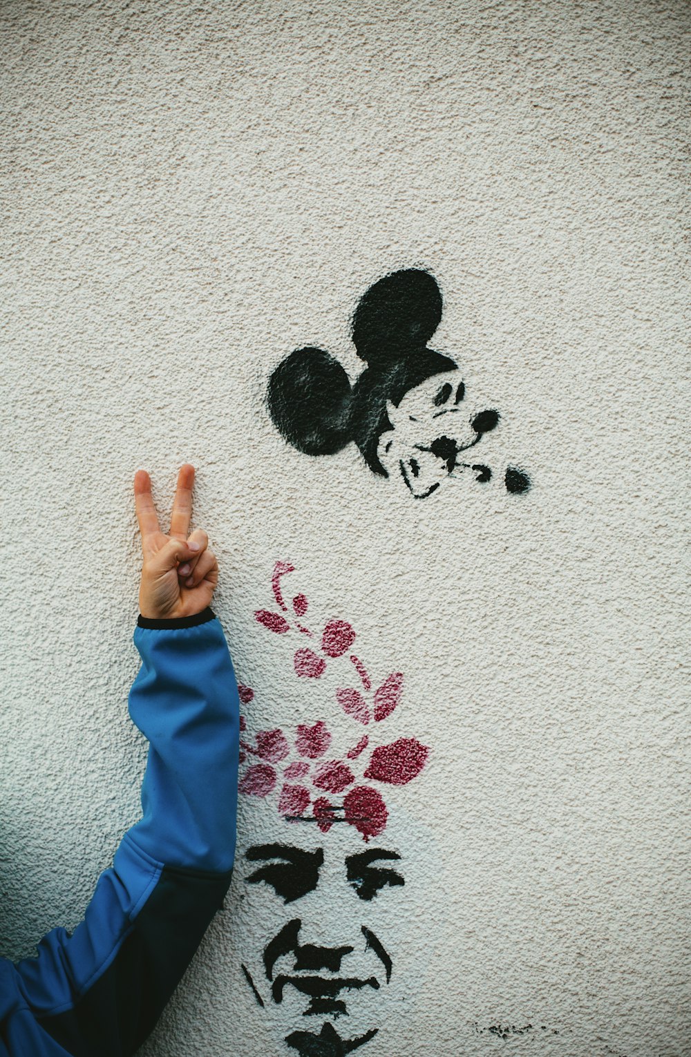 Mickey Mouse y la cara del hombre pintada en la pared