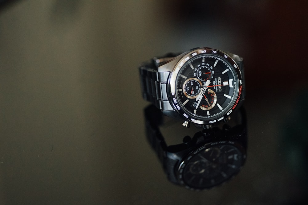round black chronograph watch with silver link bracelet
