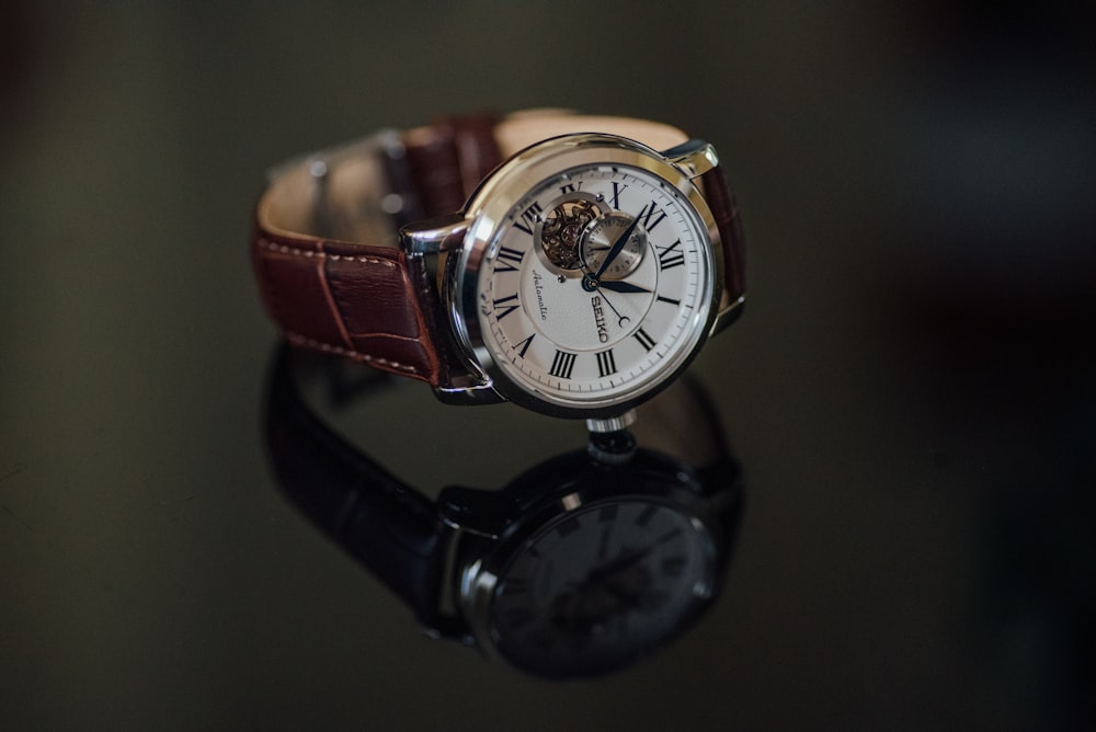 round silver-colored chronograph watch with brown leather strap