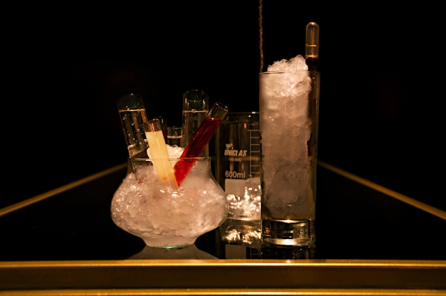 Crystal clear glassware with colorful organic solutions in a chemistry lab setting.