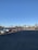 A spacious parking space with two vehicles parked under clear blue skies.