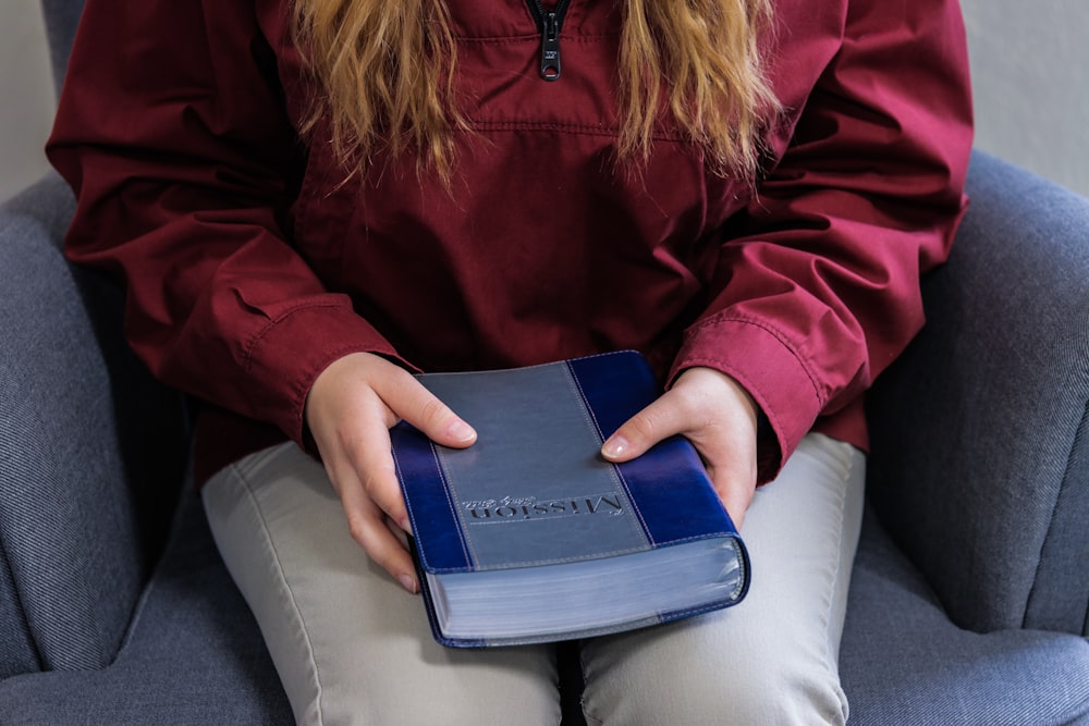 woman sitting on sofa holding book