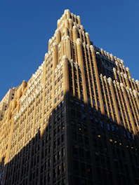 Sunlit exterior façade of 425 Madison Avenue, showcasing its classic midtown architecture against a clear blue sky.
