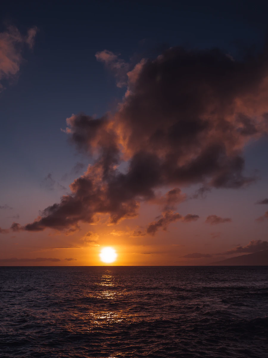 Golden hour sun setting over calm open water