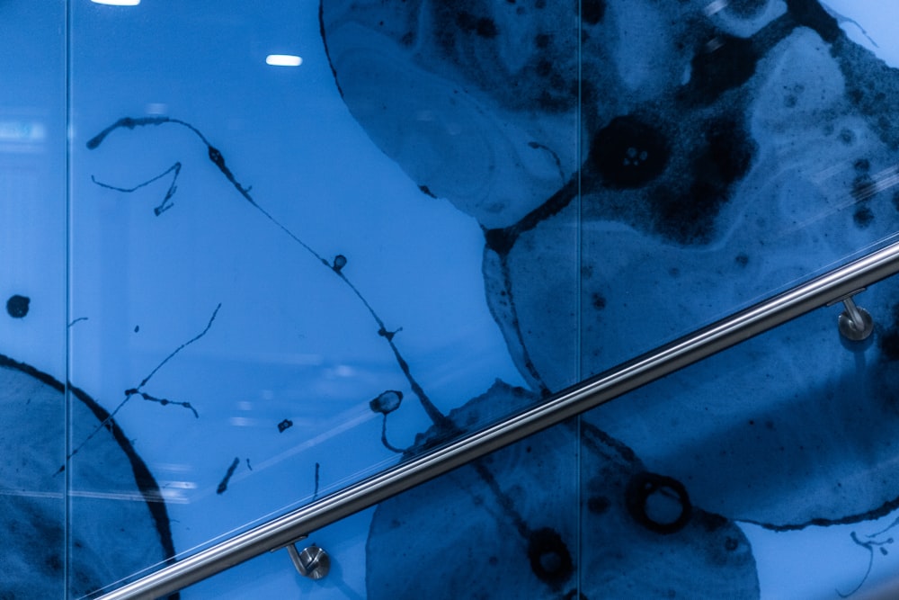 a close up of a glass railing with a painting on it