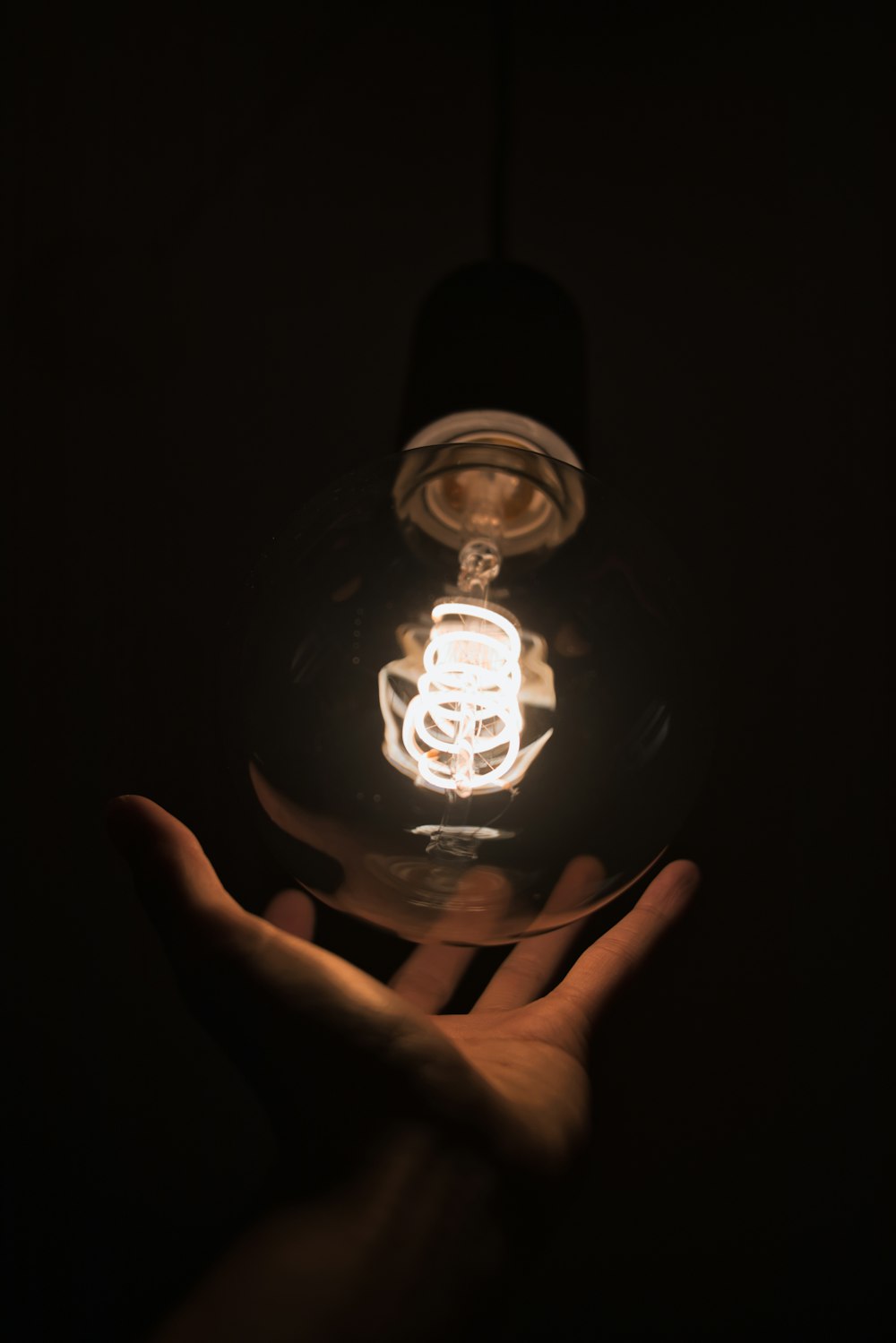 person touching light bulb