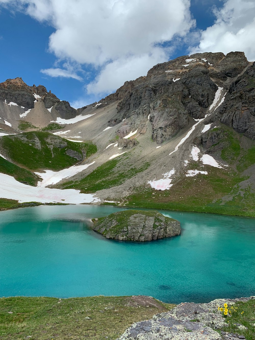 mountains near body of water under cloudy sky